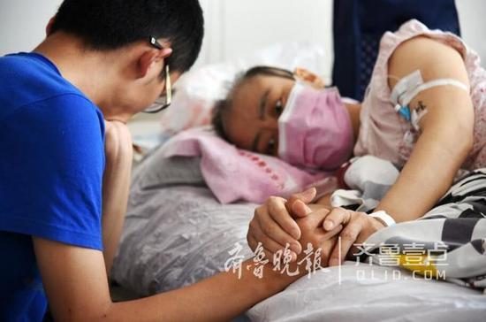 躺在病床上的母親緊緊地牽著兒子的手臂，眼神里有太多的牽掛和不舍。